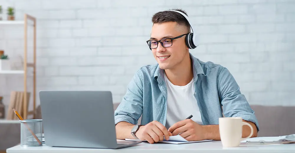 Adult learner engaged in online learning at a home workspace, representing self-paced education.